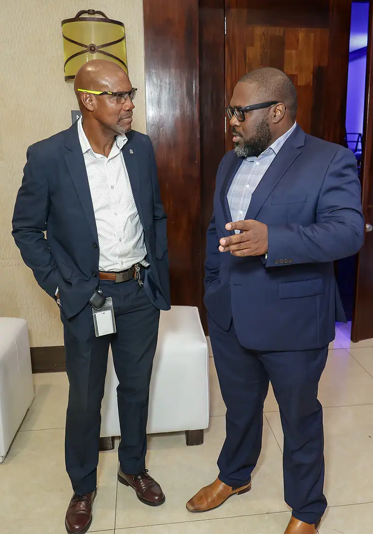Business professionals in formal attire having a conversation at a corporate event.